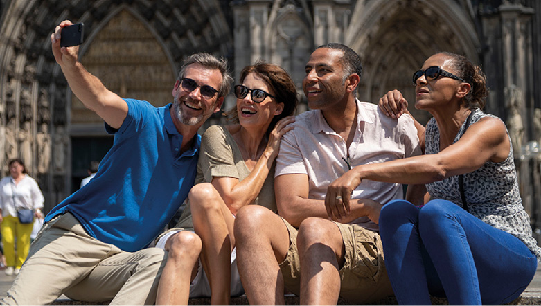 A group of four friends taking a selfie outside of Cologne Cathedral in Germany