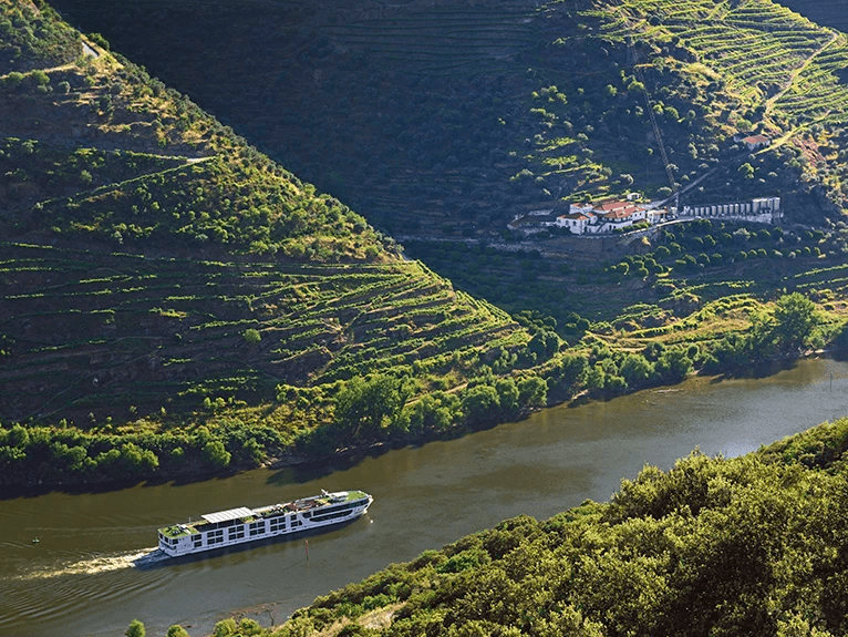 The Scenic Azure ship cruising along the Douro Valley, with green vineyards of Portugal as a charming landscape