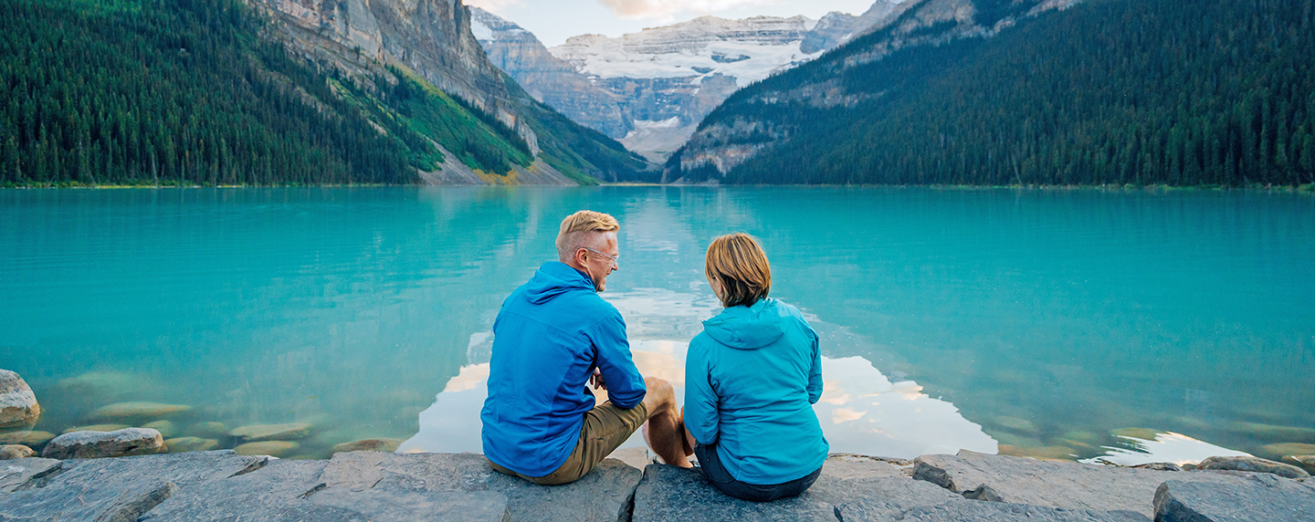 Couple sitting by Lake Louise, Canadian Rockies, Alberta, Canada
