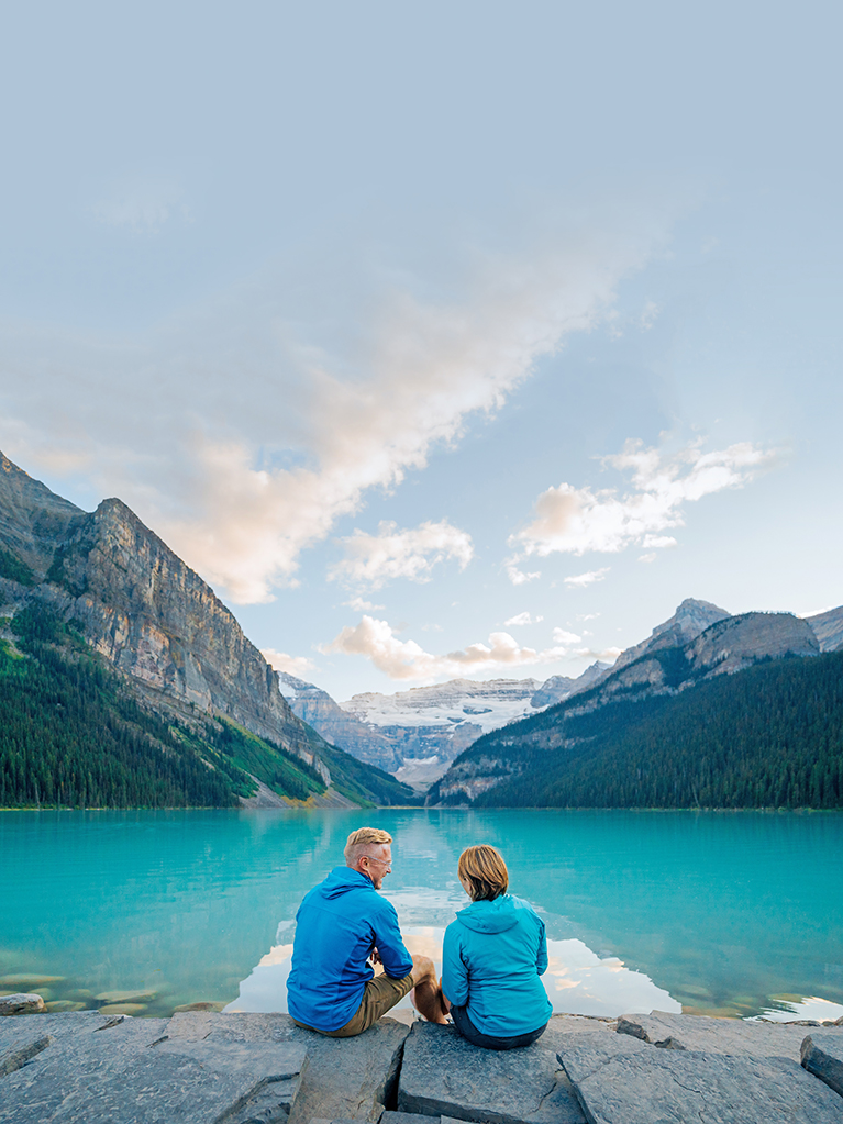 Couple sitting by Lake Louise, Canadian Rockies, Alberta, Canada
