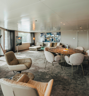 A stylish living space in your suite showcasing a round table with chairs, designed for comfort and social interaction in a warm atmosphere. 